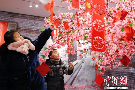 孩子們在許愿樹下寫下新年祝福。 殷立勤 攝