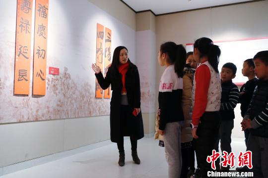 上海市文聯(lián)工作人員為孩子們講解春聯(lián)。 殷立勤 攝