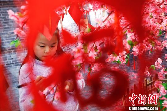 孩子在許愿樹下寫下新年祝福。 殷立勤 攝