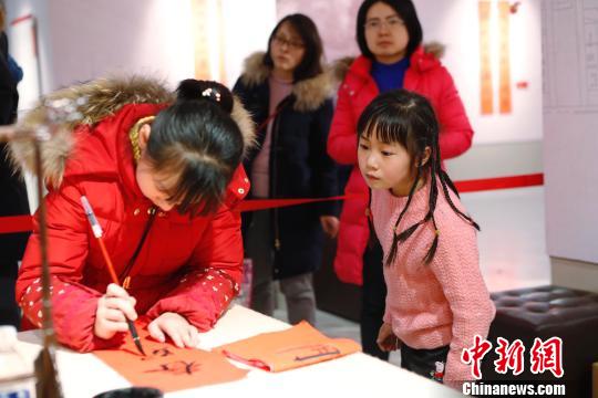 孩子在書寫春聯(lián)。 殷立勤 攝